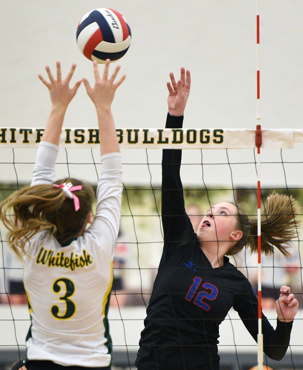 Columbia Falls' Lauren Falkner (12) goes for a kill against Whitefish's Kennedy Grove (3) at Whitefish High School on Thursday. (Casey Kreider/Daily Inter Lake)