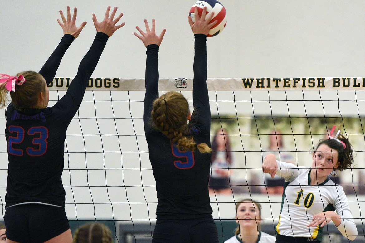 Columbia Falls' Hannah Schweikert (9) goes up for a block with teammate Ryley Kehr (23) of Whitefish's Kaiah Moore (10 at Whitefish High School on Thursday. (Casey Kreider/Daily Inter Lake)