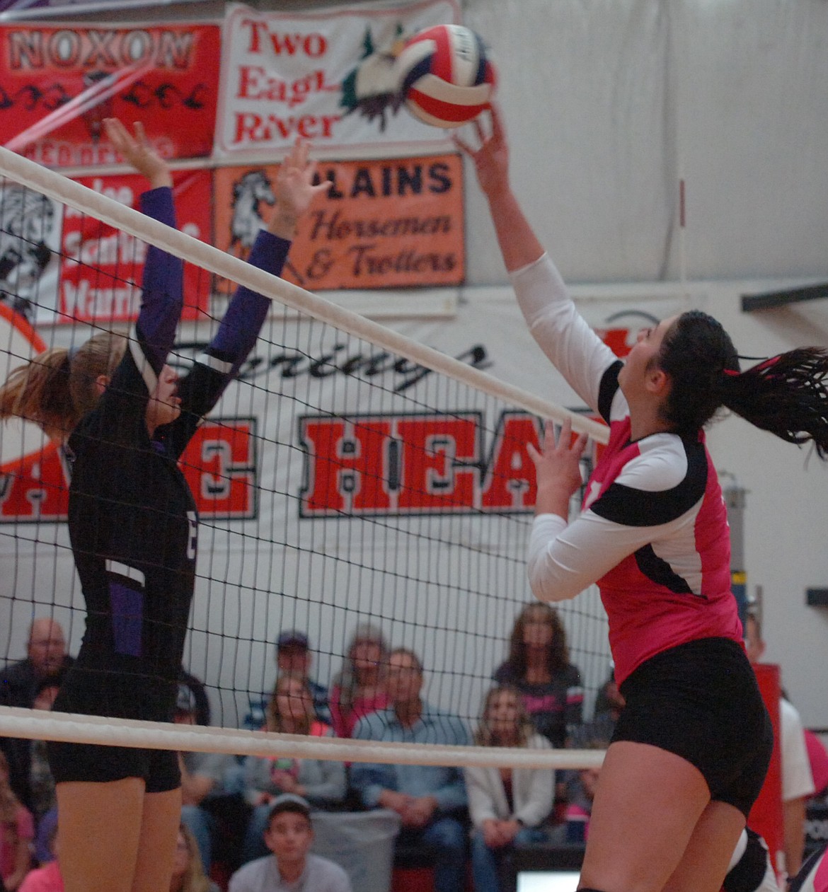 Hot Springs junior McKennzie Cannon tips the ball over an attempted block by Kira McPhail of Charlo. The Lady Savage Heat won the first set, but Charlo took the next three to stay unbeaten on the season. (Joe Sova photos/Clark Fork Valley Press)