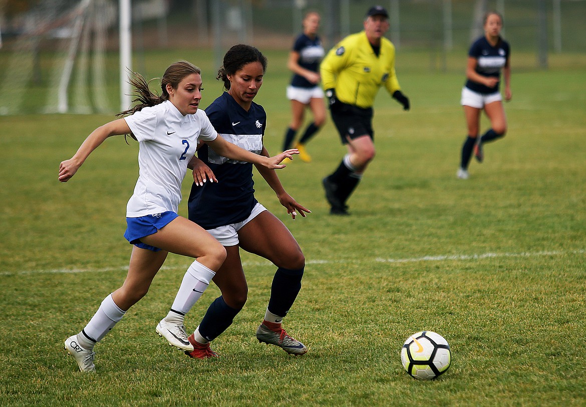 Coeur d'Alene's Adelynn Smart (2) dribbles the soccer ball downfield next to Lake City's Kali McKellips in Tuesday's Region 1 girls championship game at Lake City High School. (LOREN BENOIT/Press)