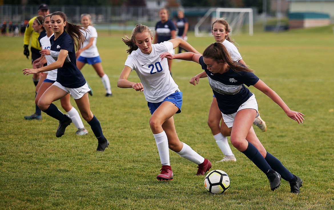 Lake City's Maddy Lasher dribbles the ball by Coeur d'Alene's Myah Rietze in Tuesday's Region 1 girls championship game at Lake City High School. (LOREN BENOIT/Press)