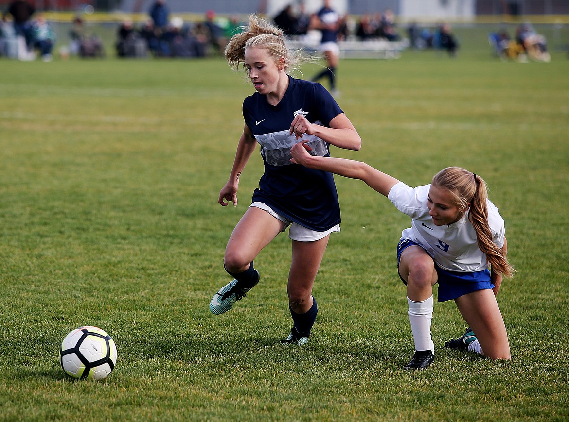Lake City's Sammie Veare dribbles the soccer ball by Coeur d'Alene's Zoe Cox in the Region 1 girls soccer championship game on Tuesday at Lake City High School. (LOREN BENOIT/Press)