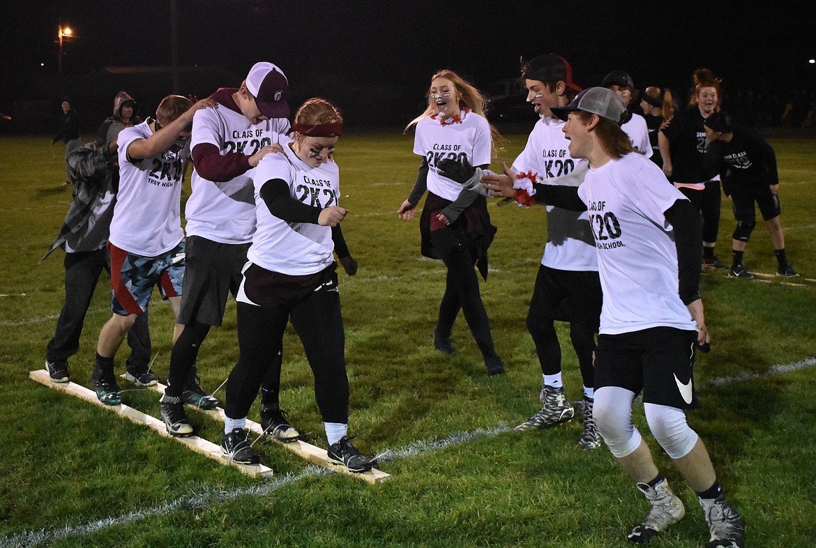 Troy High School junior Mazzy Hermes leads out fellow juniors Cody Lewis, Alex Harper and JoJo Brown as classmates cheer them on during Homecoming Game Night at the football field in Troy Wednesday. (Ben Kibbey/The Western News)