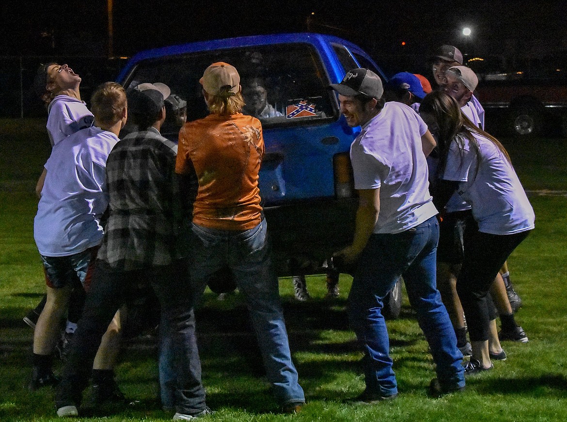 Troy High School juniors lift up the car they pushed for the competition after winning the race during Homecoming Game Night at the football field in Troy Wednesday. (Ben Kibbey/The Western News)