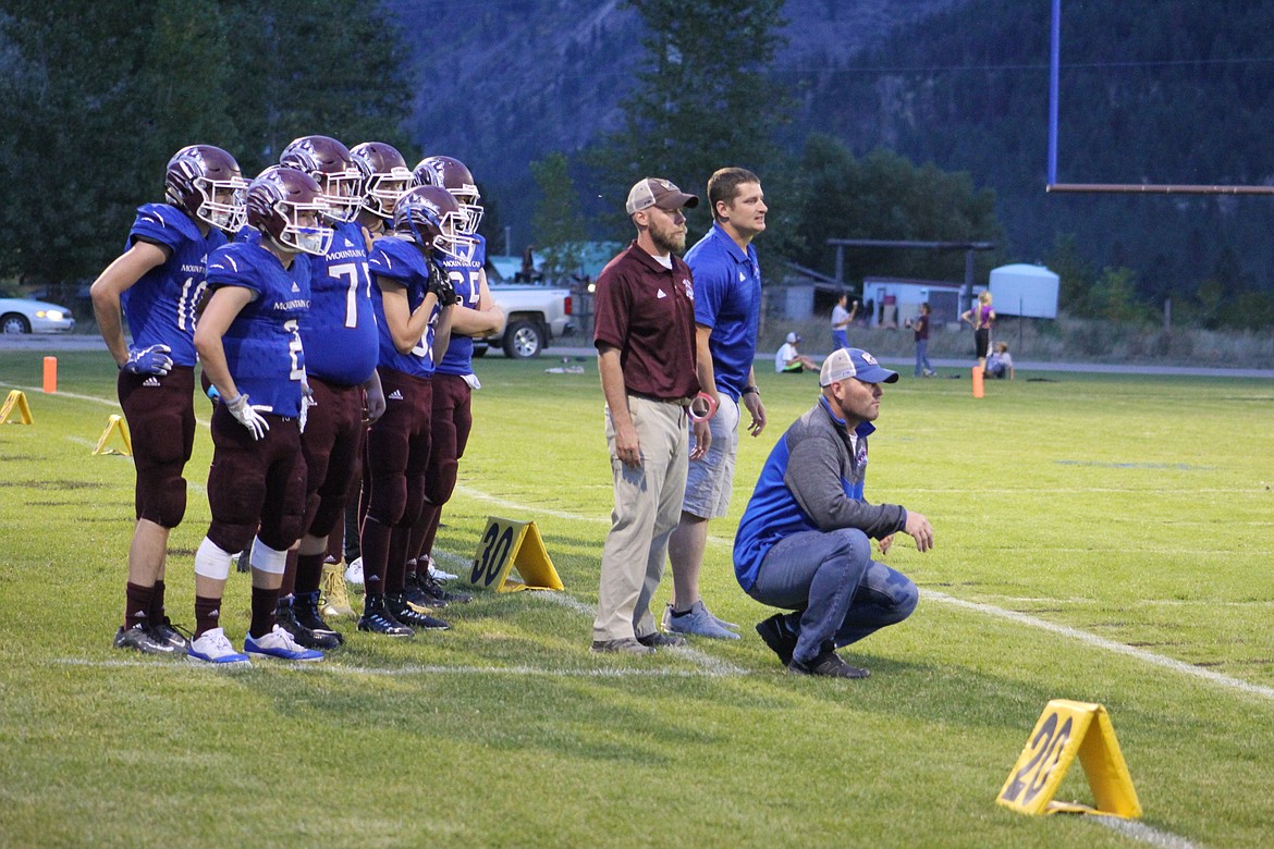 Clark Fork Mountain Cats head football coach, Jeff Schultz (middle), and assistant coaches Matt Doughty (left) and Charlie Crabb (right) call out plays to the team, who are 5-2 as of Oct. 6. (Kathleen Woodford/Mineral Independent)