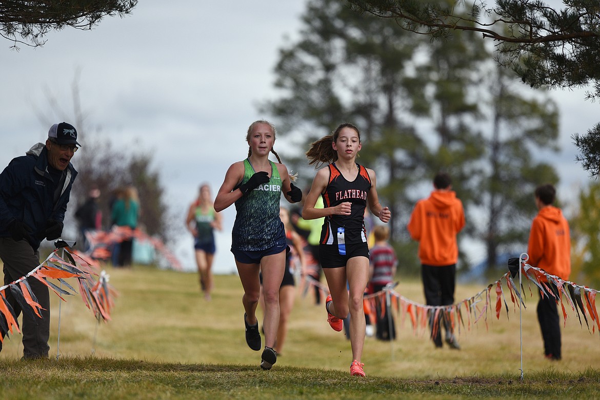 Flathead's Tori Noland-Gillespie, right, leads Glacier's Kinzie Peterson near the halfway point at the Glacier Invitational cross-country race at Rebecca Farm on Wednesday. (Casey Kreider/Daily Inter Lake)