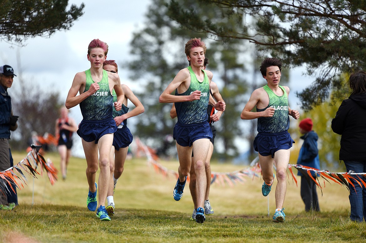 From left, Glacier's Simon Hill, Max DeVries and Aren Alexander-Battee compete in the Glacier Invitational cross-country race at Rebecca Farm on Wednesday. (Casey Kreider/Daily Inter Lake)