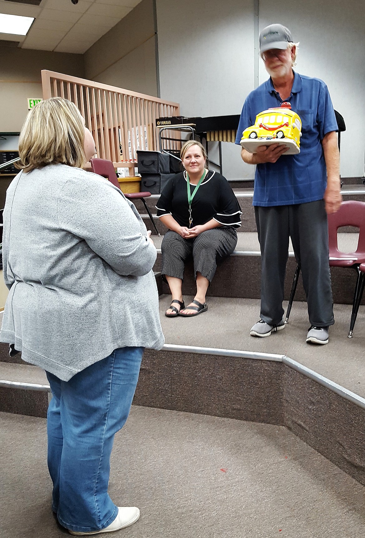St. Regis School Board Chair Charlee Thompson (left) presents Bernie Patterson with a bus cookie jar as a retirement gift during his party earlier this month. Staff members have promised to refill it monthly with his favorite cookies. (Photo provided by St. Regis School)