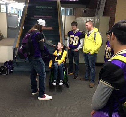 Wildcat quarterback Raiden Rickets presenting Avery Spoor with his own custome Wildcat football jersey.