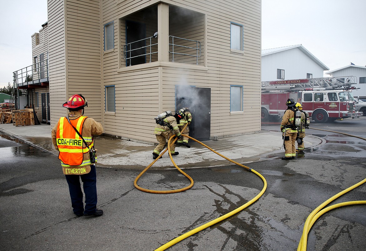 Firefighters and members of media enter a building to put out a controlled live fire during Coeur d'Alene Fire department's media day last Thursday. (LOREN BENOIT/Press)