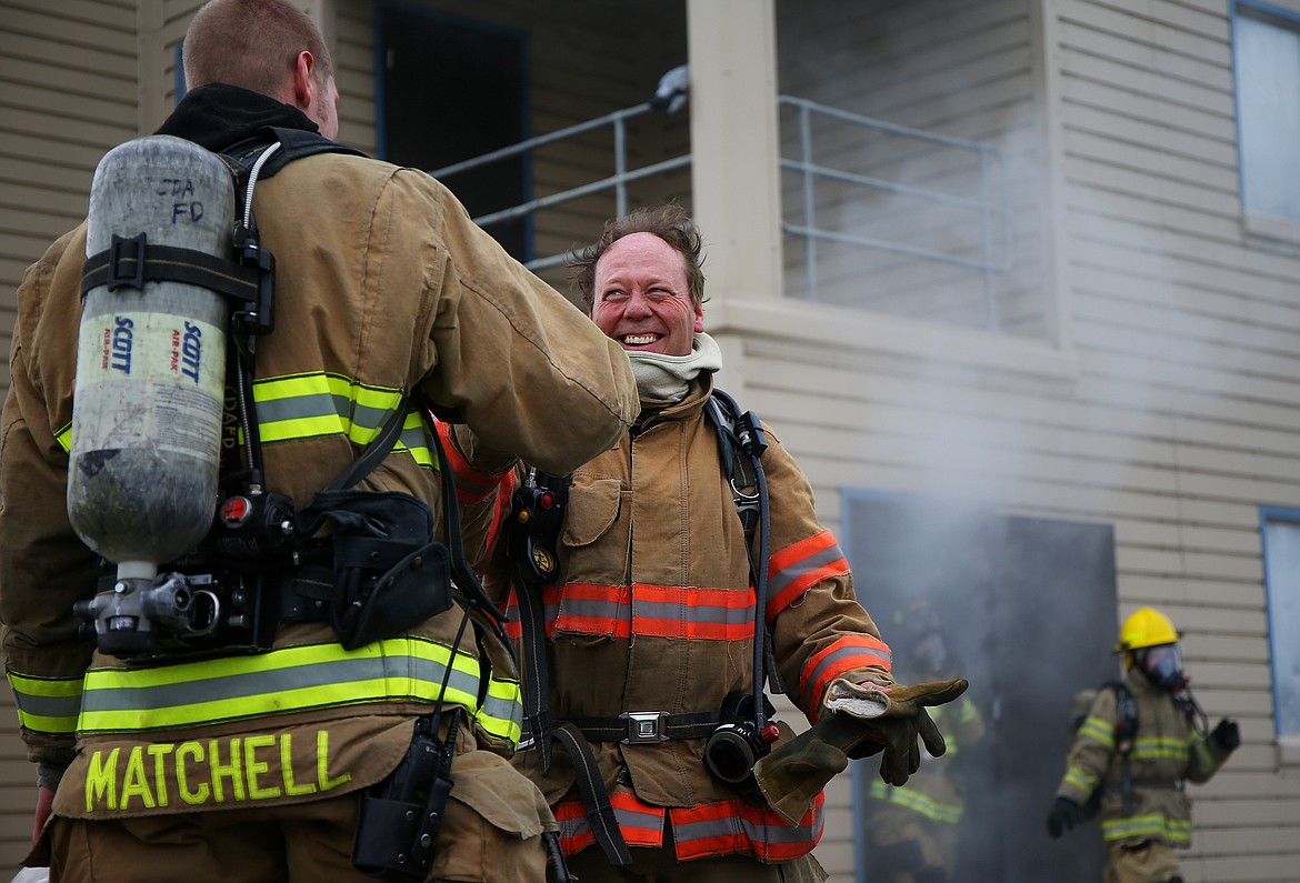 LOREN BENOIT/Press
Press reporter Brian Walker smiles and gives Coeur d&#146;Alene firefighter Chad Matchell a handshake after successfully rescuing two &#147;victims&#148; from a controlled live fire scenario last Thursday at the fire station off Ramsey and Kathleen.