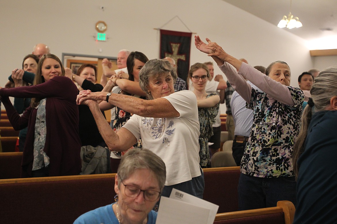 Jean Davis, center, and Julie Paige Anderson, right, stretch prior to singing during Chorale Coeur d'Alene's Sept. 18 rehearsal. The Chorale is preparing for its 17th year presenting sacred chorale music to the community, beginning with the &quot;Made in the USA&quot; concert Nov. 8 in Trinity Lutheran Church in Coeur d'Alene. (DEVIN WEEKS/Press)