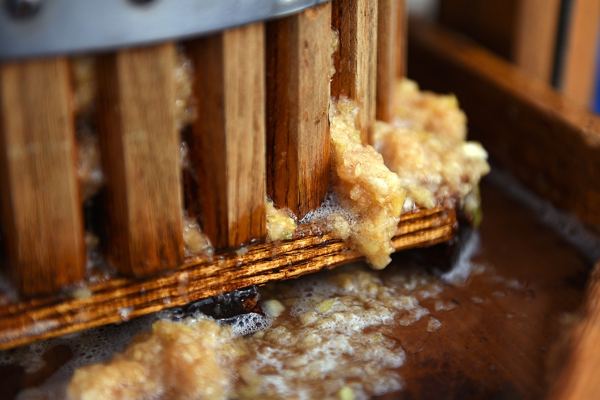 Bits of apple are squeezed from the press while making unpasteurized cider at Apple Barrel Country Market on Thursday. (Casey Kreider/Daily Inter Lake)