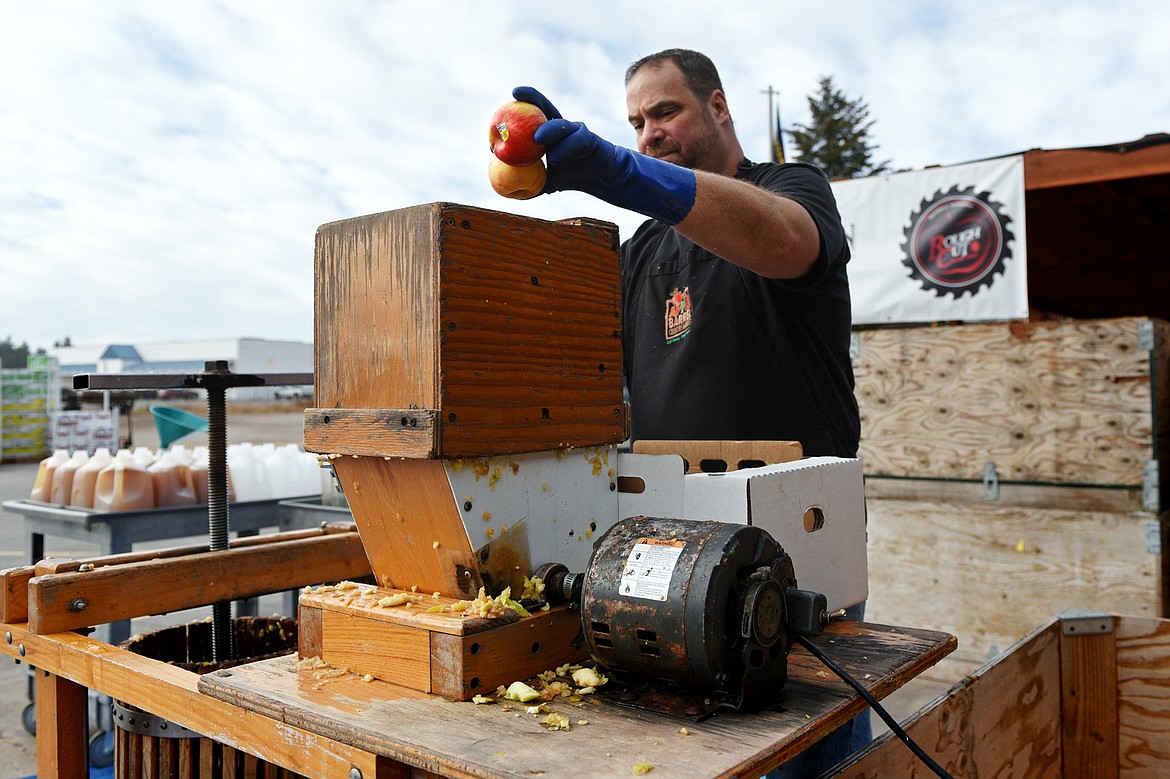 Brook Peterson adds Jonagold apples to a batch of unpasteurized cider at Apple Barrel Country Market on Thursday. (Casey Kreider/Daily Inter Lake)