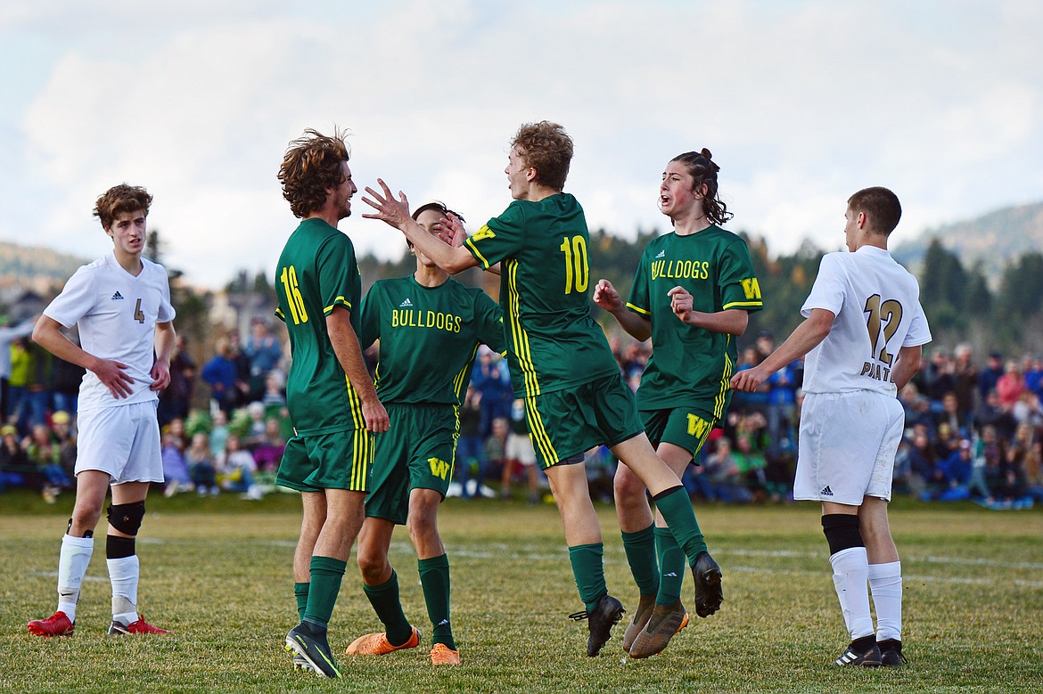 Whitefish's Xander Burger (16) celebrates with teammates Brandon Mendoza (8), Casey Schneider (10) and James Thompson (17) after Burger's fourth goal of the game in the Class A state soccer championship against Polson at Smith Fields in Whitefish on Saturday. Whitefish won, 6-2. (Casey Kreider/Daily Inter Lake)