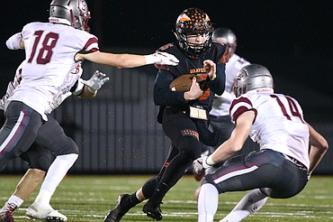 Flathead quarterback Jaden MacNeil (15) is brought down by Helena defenders Cooper Biegler (18) and Zachary Spiroff (14) on a first-quarter run at Legends Stadium on Friday. (Casey Kreider/Daily Inter Lake)