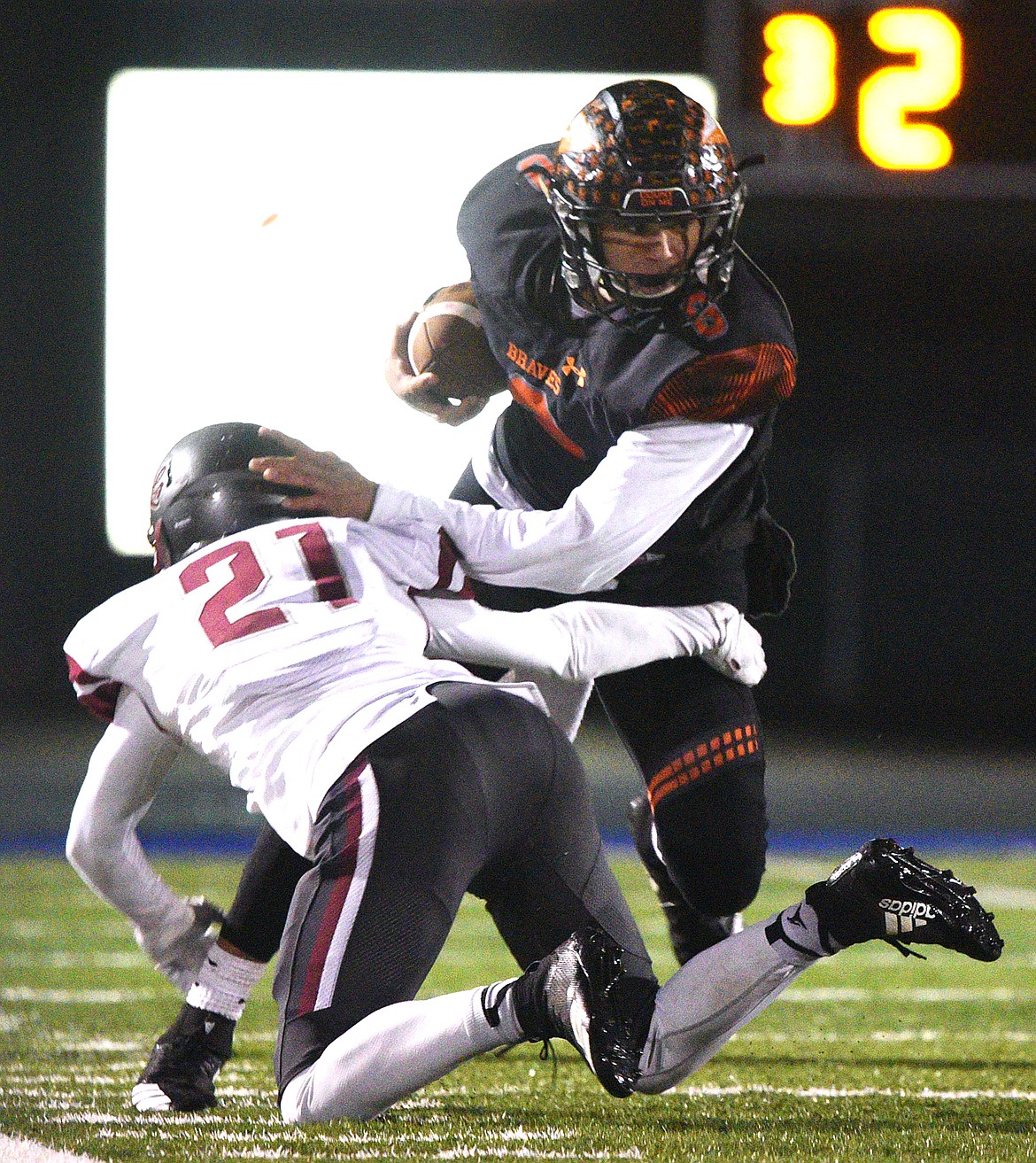 Flathead's Anthony Jones (8) breaks the tackle of Helena's David Lowry (21) after a third-quarter reception at Legends Stadium on Friday. (Casey Kreider/Daily Inter Lake)