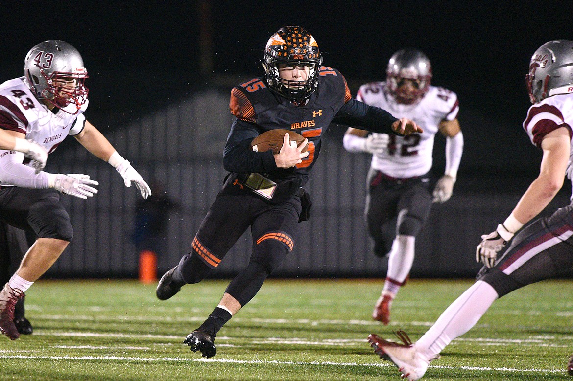 Flathead quarterback Jaden MacNeil (15) looks for room to run in the first quarter against Helena at Legends Stadium on Friday. (Casey Kreider/Daily Inter Lake)