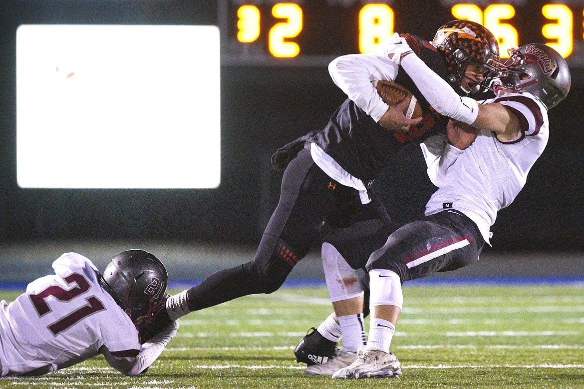 Flathead's Anthony Jones (8) fights for extra yardage against Helena's David Lowry (21) and Connor Murgel (1) after a third-quarter reception at Legends Stadium on Friday. (Casey Kreider/Daily Inter Lake)