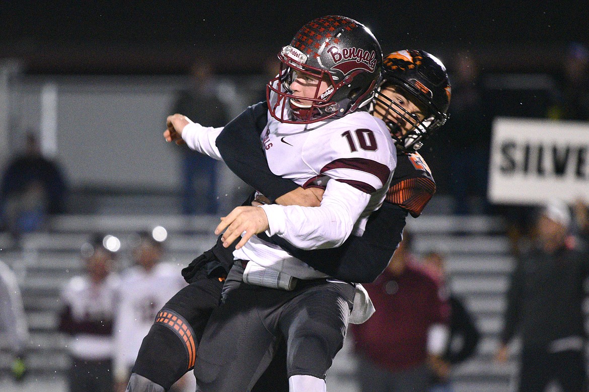 Flathead defensive end Gannon Welder (23) hits Helena quarterback Ty McGurran (10) after a second-quarter pass at Legends Stadium on Friday. (Casey Kreider/Daily Inter Lake)