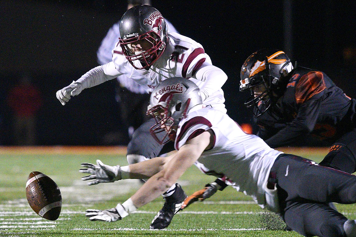 Helena's Zachary Spiroff (14) and David Lowry (21) and Flathead's Brian Wells (13) dive on a fumble on a Helena punt return in the first quarter at Legends Stadium on Friday. Helena recovered the fumble. (Casey Kreider/Daily Inter Lake(