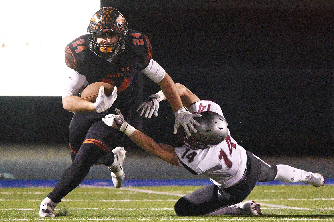 Flathead running back Blake Counts (24) looks to break the tackle of Helena's Zachary Spiroff (14) on a second-quarter reception at Legends Stadium on Friday. (Casey Kreider/Daily Inter Lake)