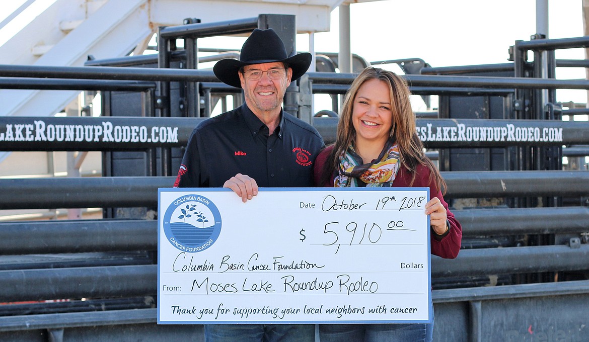 Courtesy photo
Moses Lake Roundup Chairman Mike Harris presents a check for $5,910 to Angel Ledesma of the Columbia Basin Cancer Foundation. The money was raised through the Tough Enough to Wear Pink program at last Augusts rodeo and will help local cancer patients with financial burdens, counseling, support groups, medical advice and many other services.