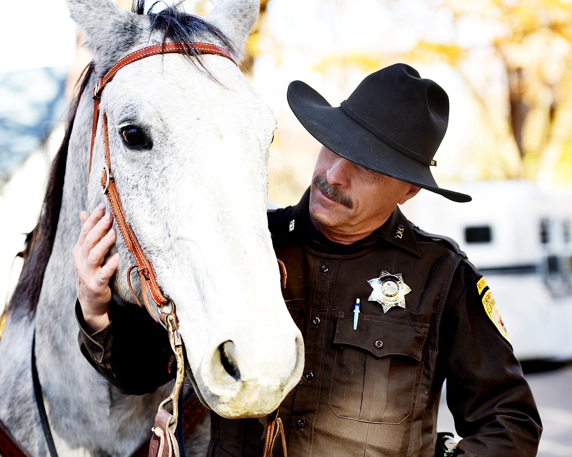 Reserve Deputy Ron Eckert, the Mounted Unit Leader of the Sheriff's Posse, with Jay, his dapple gray quarter horse in Kalispell on Thursday, October 18.(Brenda Ahearn/Daily Inter Lake)