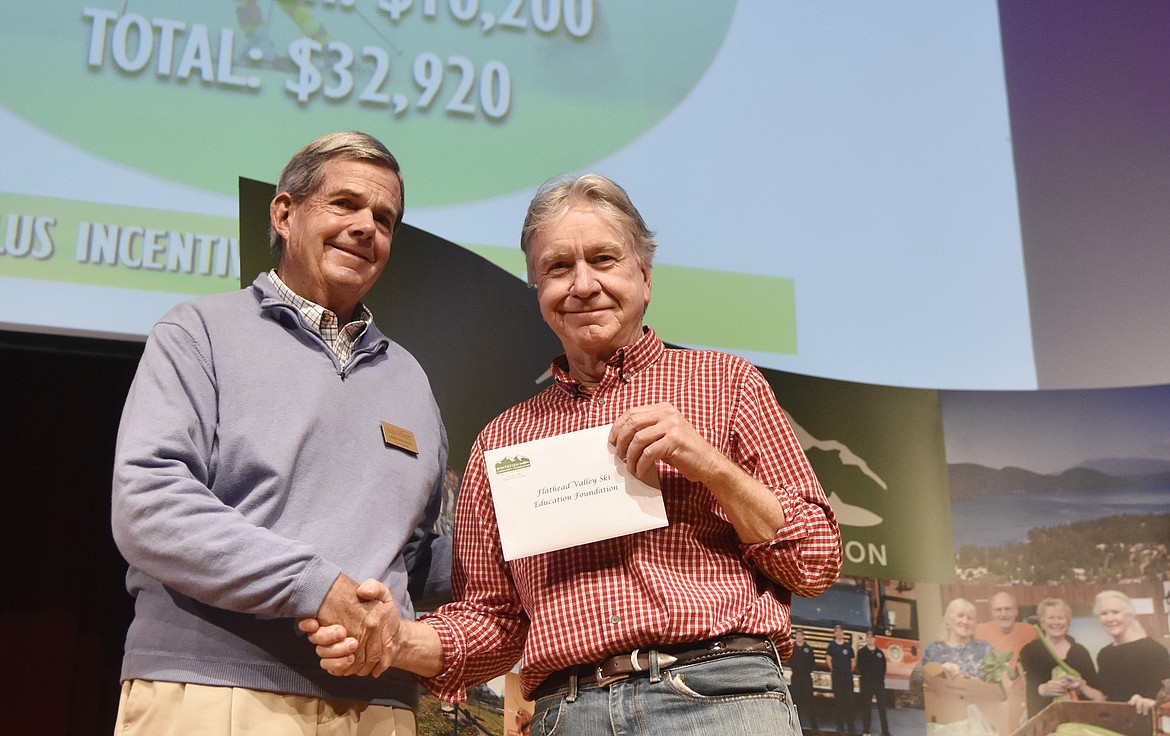 Jamie Shennan, with the Whitefish Community Foundation, presents a check to Tim Hinderman, with the Flathead Valley Ski Education Foundation Thursday during the Great Fish Community Challenge awards at the Whitefish Performing Arts Center. (Heidi Desch/Whitefish Pilot)