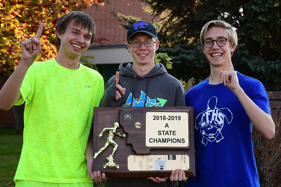 Beau Umbriaco, Joe Lamb and Bryce Bennett show off Columbia Falls&#146; new state championship trophy Monday.(Jeremy Weber photo)