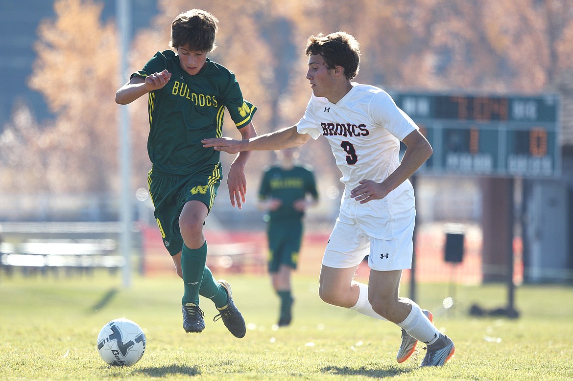 Whitefish's Gabe Menicke (9) pushes the ball upfield against Frenchtown's Mediah Morin (9) at Smith Fields in Whitefish on Saturday. (Casey Kreider/Daily Inter Lake)