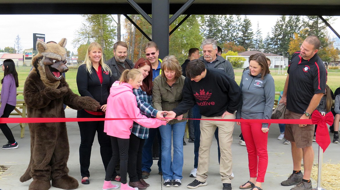 Glacier High School freshmen Madison West and Sephy David and Flathead High School junior Kord Collier return to Evergreen School District to cut the ribbon on a new pavilion that was an idea supported by their eighth-grade classes while they attended Evergreen Junior High. Pictured front row left to right: West; David; Evergreen School District board chairwoman,Tamara Williams; Collier; Evergreen Junior High teacher Melissa Hardman; East Evergreen Elementary teacher Cliff Thorsen; back row: Waldo the Wolverine; Evergreen Junior High teacher Kara Gronley; Evergreen School District board trustee Jon Wilson; Evergreen School District board vice chairman Dave Lowitz; and Evergreen School District board trustee Paul Wigle.