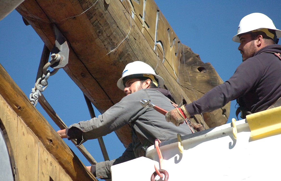 Bryce Finley and Richard LaRance work to remove the Ronan sign from its supports. The sign was down and on its way to restoration in less than an hour Oct. 17.