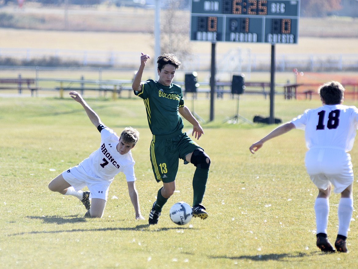 Bulldog Joshua Gunderson protects the ball from Frenchtown players during the first half of the semifinal playoff game Saturday at Smith Fields. (Heidi Desch/Whitefish Pilot)