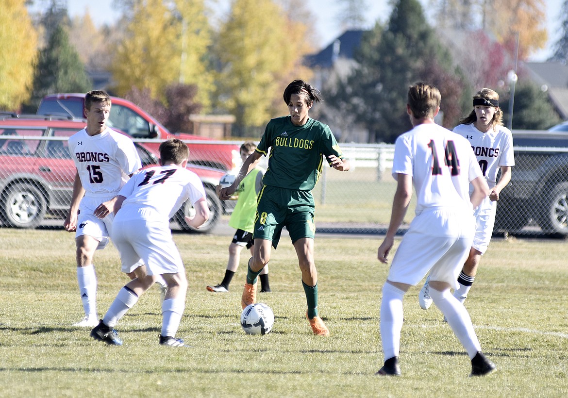 Bulldog Brandon Mendoza looks to move the ball through a group of Frenchtown defenders Saturday during the first half of the semifinal game at Smith Fields. (Heidi Desch/Whitefish Pilot)