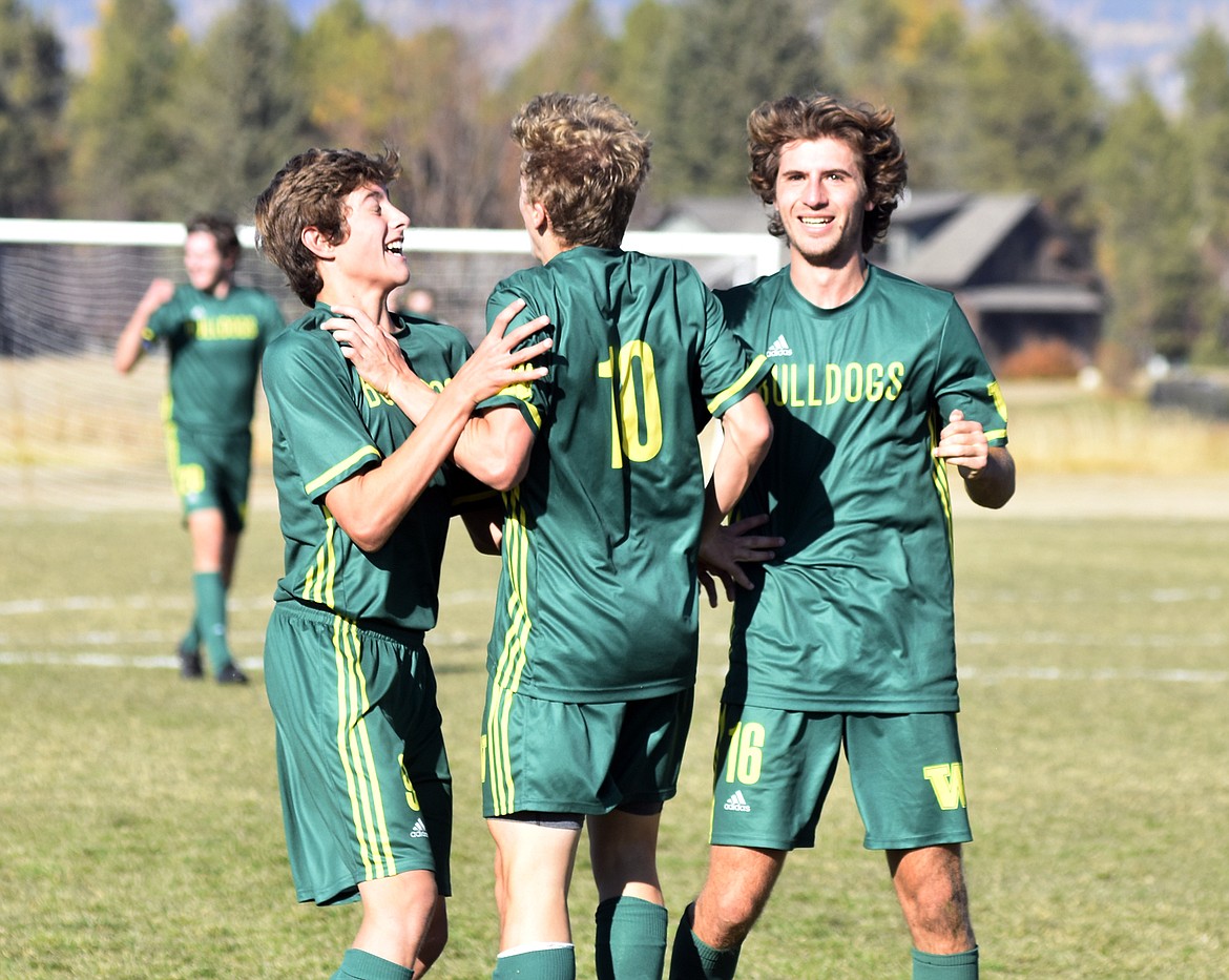 Fellow Bulldogs congratulate Casey Schneider (10) after he scored the Bulldogs&#146; only goal of the game Saturday at Smith Fields. (Heidi Desch/Whitefish Pilot)