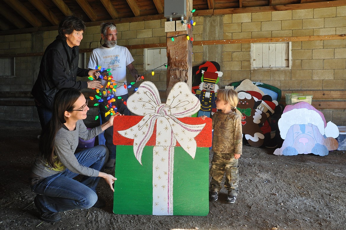 Clockwise from bottom left are Brianna Ewert, Mary Ann Ewert, Brian Ewert and Carmody Ewert. The family volunteered to help start set up for Lights Under the Big Sky Saturday, starting with testing strings of lights. (Ashley Fox/Lake County Leader)