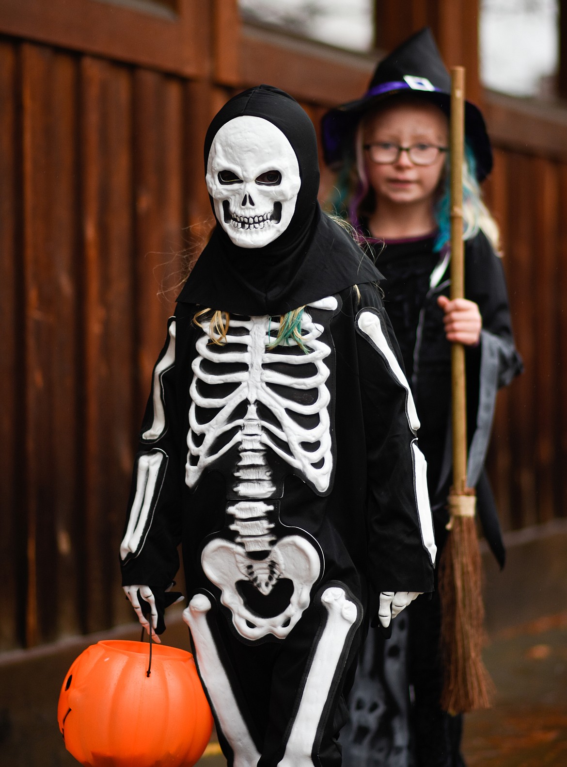 A skeleton and a witch look for treats in downtown Whitefish during Halloween Wednesday. (Daniel McKay/Whitefish Pilot)