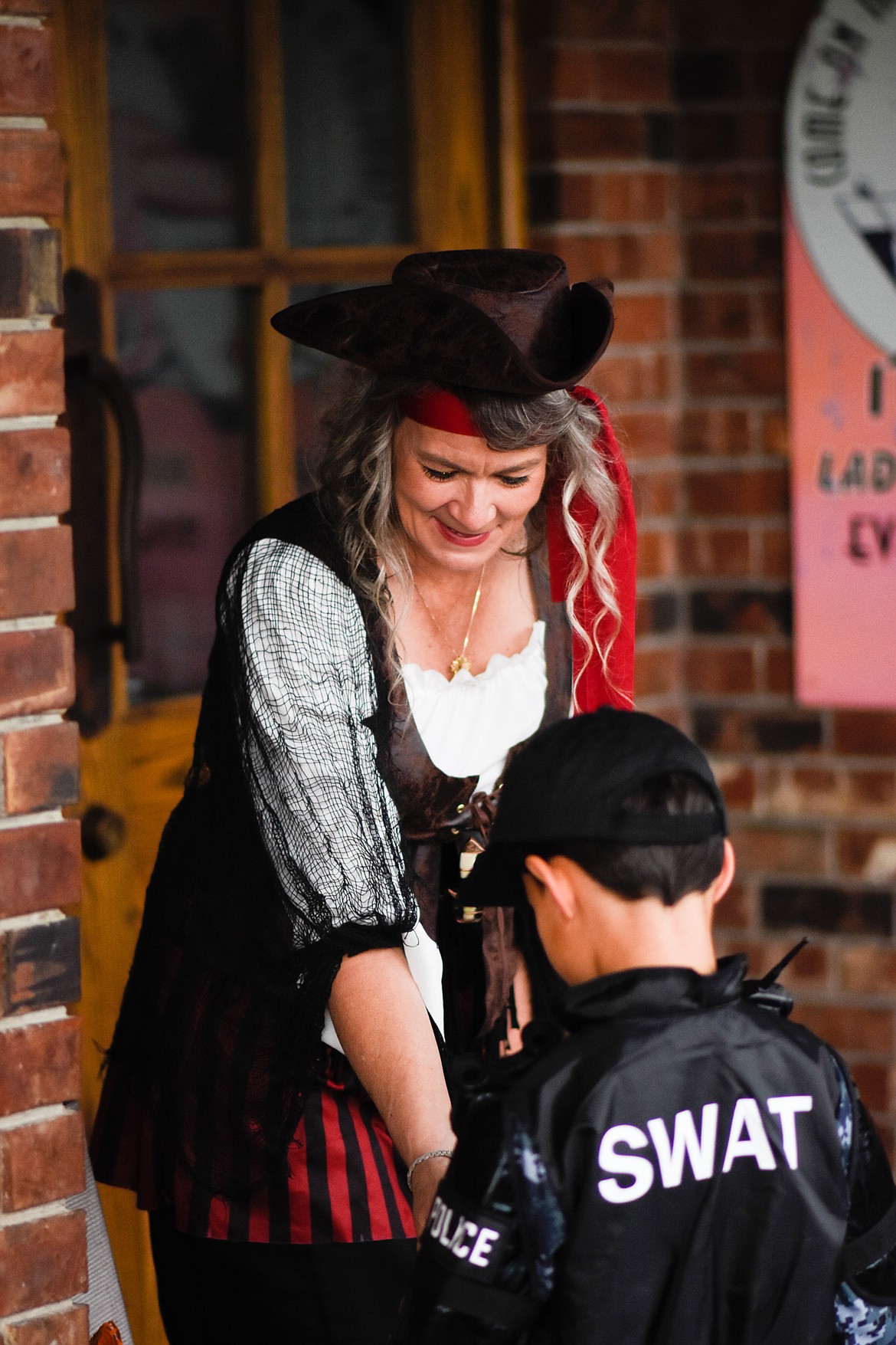 A SWAT officer inspects the candy offerings in downtown Whitefish during Halloween Wednesday. (Daniel McKay/Whitefish Pilot)