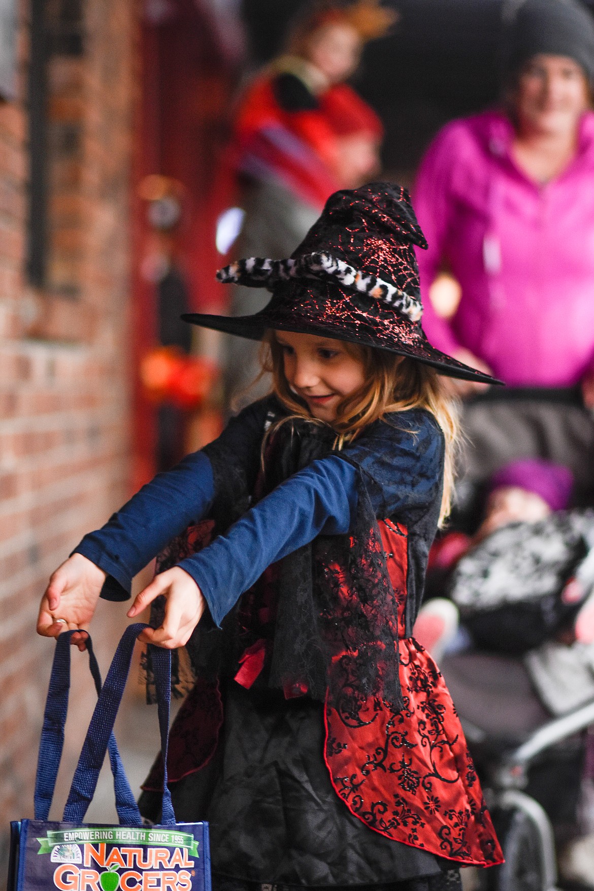 An eager witch hopes for candy in downtown Whitefish during Halloween Wednesday. (Daniel McKay/Whitefish Pilot)