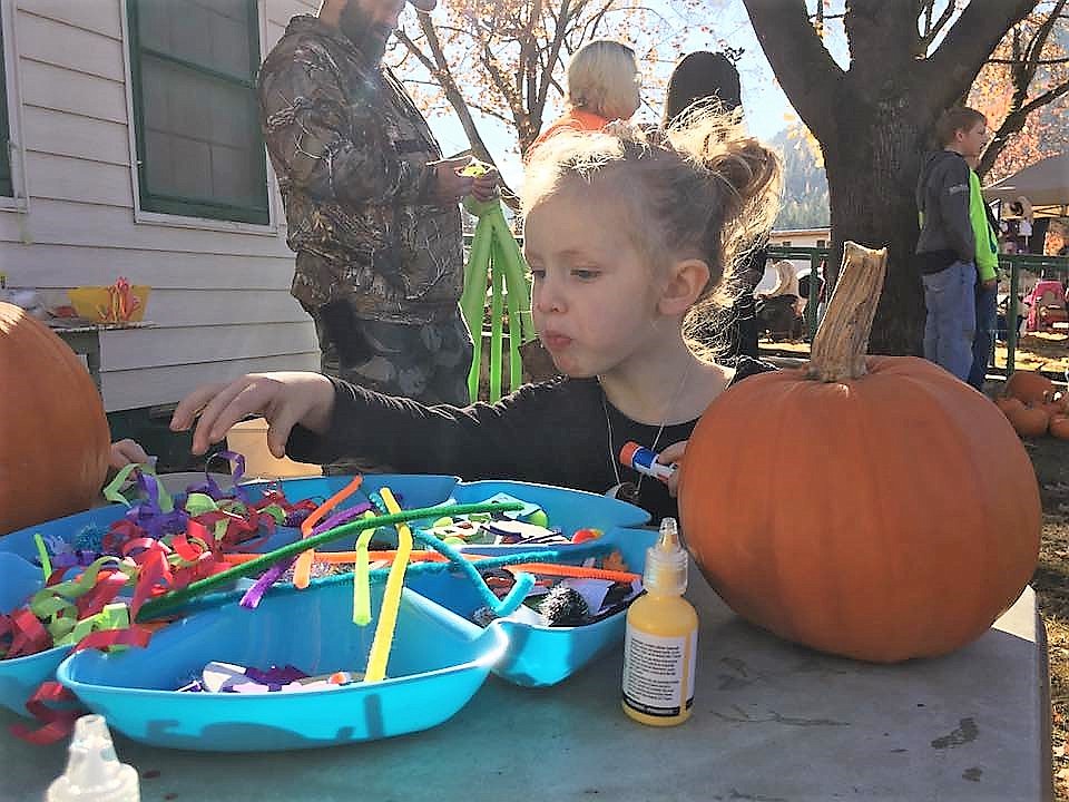 Kenadie Schultz, 2, decorates her pumpkin during the Mineral County Library annual Pumpkin Decorating and Costume Contest on Saturday. (Photo courtesy of Florence Evans)