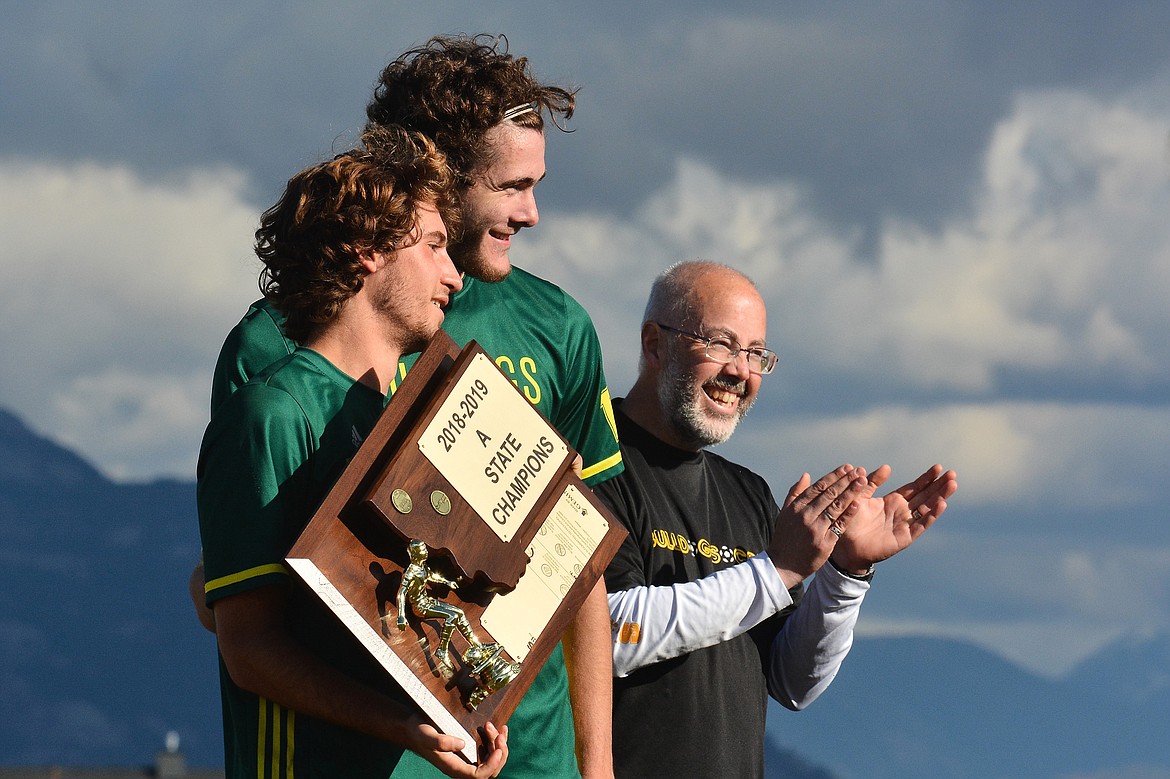 Following Whitefish&#146;s win, team captains Xander Burger and Sam Menicke hold the trophy, alongside Head Coach John Lacey. (Photo courtesy Jeff Doorn)