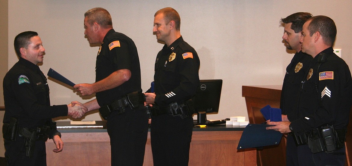 Post Falls police Officer Chris Christensen, far left, 
receives a Life Saving Award from Chief Pat Knight. In the middle is Capt. Jason 
Mealer. Other award recipients, Officer Nathan Schrag and Sgt. Brian 
Harrison, far right, look on. (BRIAN WALKER/Press)