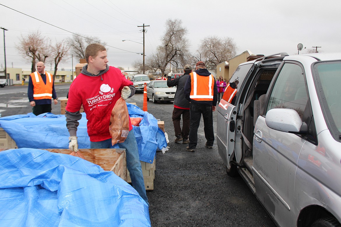 Cheryl Schweizer/Columbia Basin Herald
Volunteer Andrew Mansfield distributes potatoes as part of the annual Moses Lake Food Bank Thanksgiving basket distribution last year. This year&#146;s distribution is Nov. 19-21.