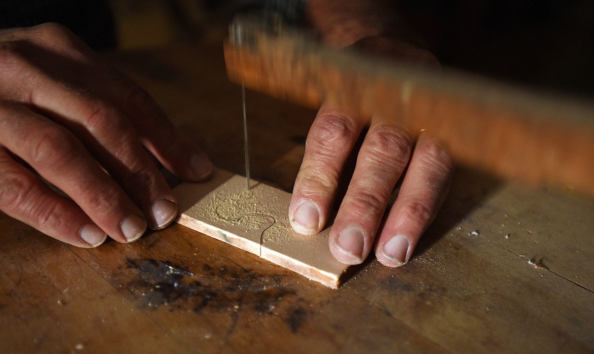 Steve Morley demonstrates the jigsaw from 1876 that is still at use at Morley Cedar Canoes in Swan Lake.
(Brenda Ahearn/Daily Inter Lake)