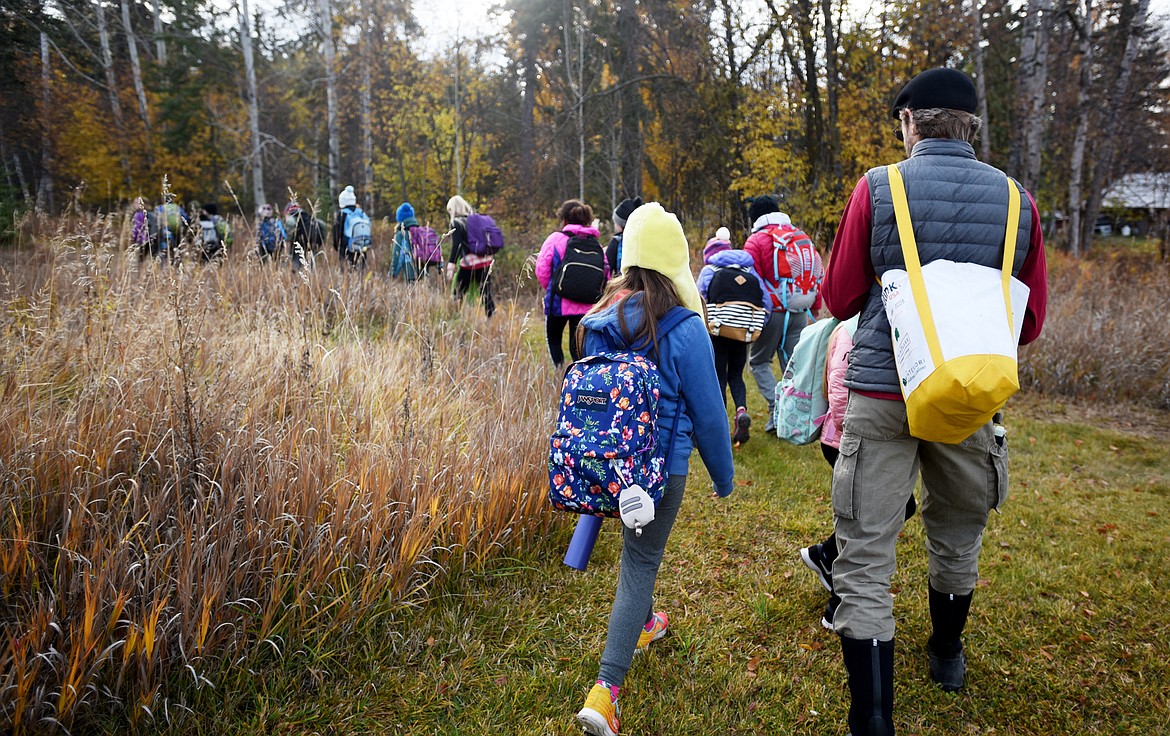 Kalispell Montessori teacher David Cummings and a group of students follow Flathead Audubon Conservation Educator Denny Olson into the Owen Sowerwine Natural Area on Thursday, October 25.(Brenda Ahearn/Daily Inter Lake)