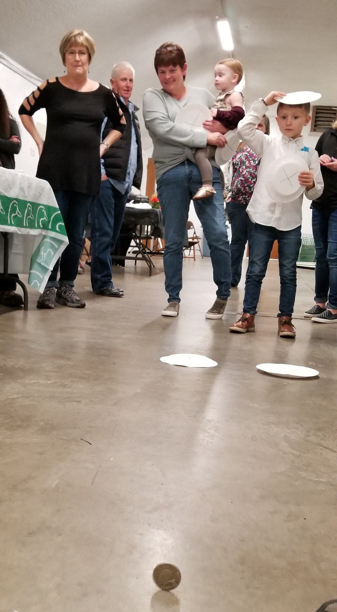 Photo by MANDI BATEMAN
The winner of the children&#146;s Heads or Tails game watches the coin as it spins before landing.