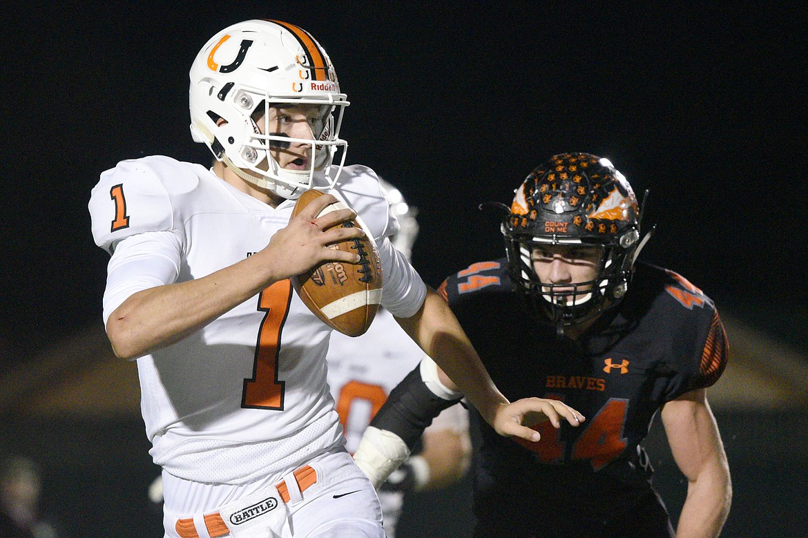 Billings Senior quarterback Matt Plasterer (1) is pressured by Flathead linebacker Tanner Russell (44) in the first quarter of a Class AA quarterfinal playoff game at Legends Stadium on Friday. (Casey Kreider/Daily Inter Lake)