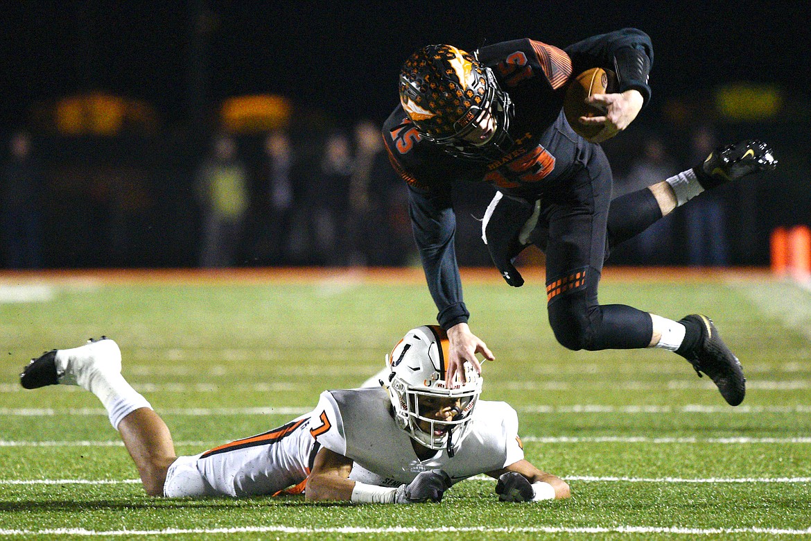 Flathead quarterback Jaden MacNeil (15) is upended by Billings Senior defensive back Junior Bergen (7) on a first quarter run in a Class AA quarterfinal playoff game at Legends Stadium on Friday. (Casey Kreider/Daily Inter Lake)