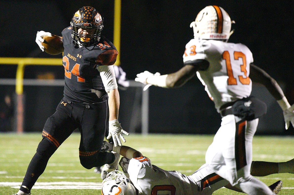 Flathead running back Blake Counts (24) stiff-arms Billings Senior defender Alyas Wright (10) on a third quarter run in a Class AA quarterfinal playoff game at Legends Stadium on Friday. (Casey Kreider/Daily Inter Lake)